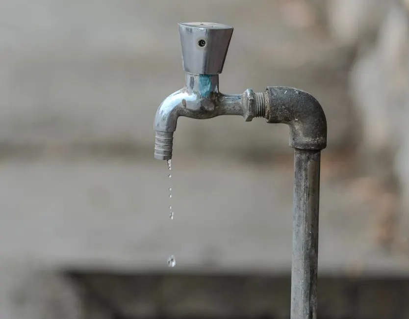 Outdoor faucet dripping onto concrete